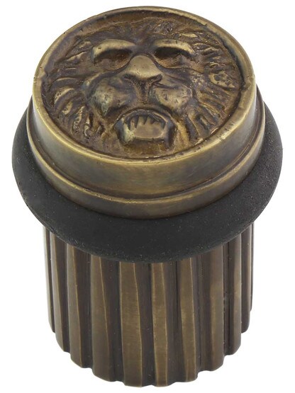 Brass Lion Head Floor-Mount Door Stop in Antique Brass.